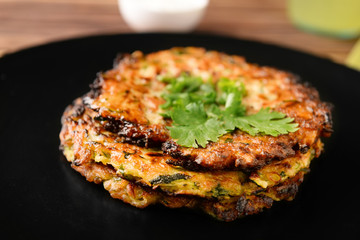 Tasty zucchini pancakes on plate, closeup