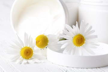 Fototapeta na wymiar Jar of face cream or body cream with camomile flower