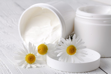 Obraz na płótnie Canvas face cream or body cream with camomile flower