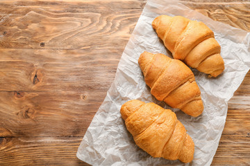 Tasty croissants on wooden table