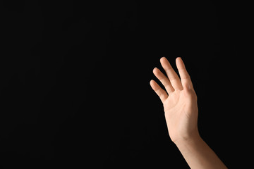 Fototapeta premium Young woman using virtual screen on dark background