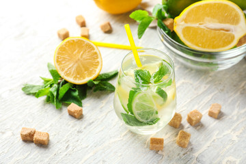 Glass of fresh mojito on light wooden table