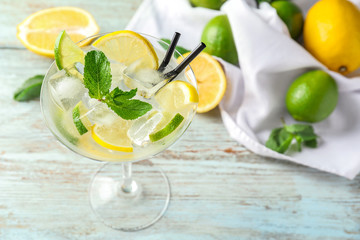 Glass of fresh mojito on light wooden table