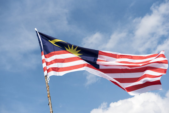 Malaysia flag also known as Jalur Gemilang wave with the blue sky. People fly the flag in conjunction with the Independence Day celebration or Merdeka Day.