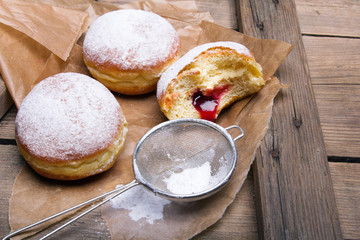 Tradycyjne Polskie pączki na drewnianym tle. Smaczne paczki z dżemem. © czarny_bez