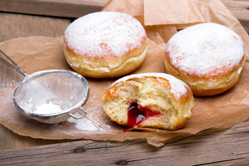 Traditional Polish donuts on wooden background. Tasty doughnuts with jam.