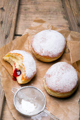 Traditional Polish donuts on wooden background. Tasty doughnuts with jam.