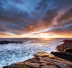 Seascape during storm and sunrise, Lofoten islands, Norway. Wave and stones on seashore. Natural seascape in the Norway. Lofoten island at the sunrise