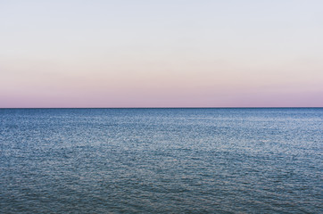 Evening seascape with endless horizon and calm water
