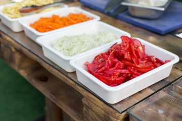 products for cooking falafel in dishes on a wooden table. Street food ready to serve on a food stall.