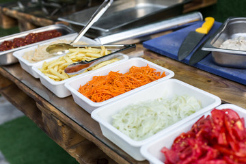 products for cooking falafel in dishes on a wooden table. Street food ready to serve on a food stall.