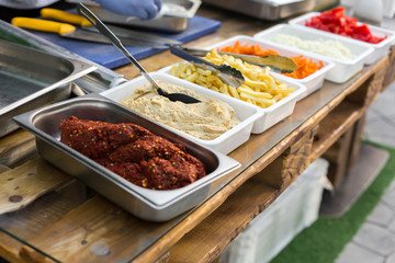 products for cooking falafel in dishes on a wooden table. Street food ready to serve on a food stall.