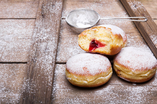 Traditional Polish donuts on wooden background.  Tasty doughnuts with jam.