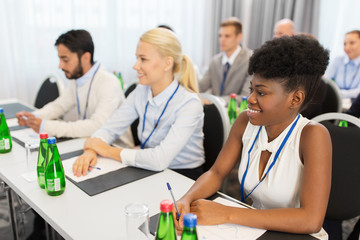 business and education concept - group of people at international conference or lecture