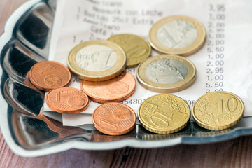 Tipping in Europe. Bill and payment, coins on tip tray