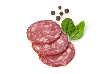 Sliced salami smoked sausage, basil leaves and peppercorns, isolated on white background.