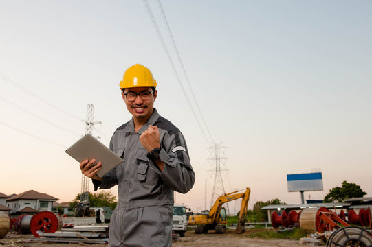 Asian engineer holding a tablet is delighted at construcktion site,Asian engineer congrate with his job successed