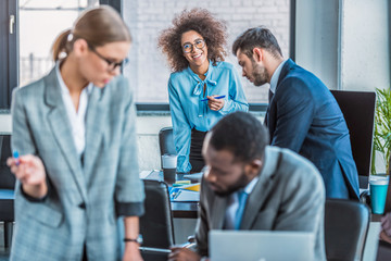 smiling african american businesswoman looking at camera in office