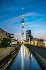 TOKYO, JAPAN - June 22, 2018: Tokyo Skytree, Sumida Ward Urban night scene. Tokyo Skytree tower reflections on the canal. Tokyo Sky Tree is one of the famous landmark in Tokyo.