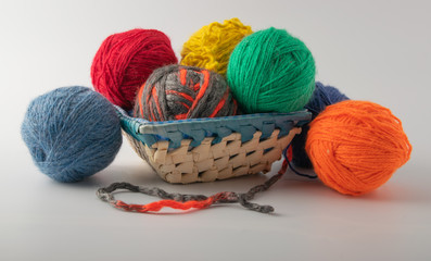 multicolored wool knitting balls in the basket. supplied on a light background