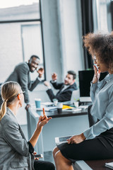 businesswoman showing middle finger to colleagues in office