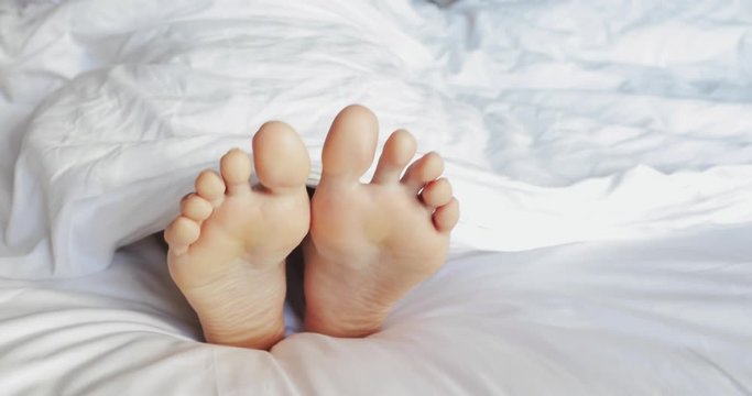 Woman Feet Dancing in Bed. Closeup