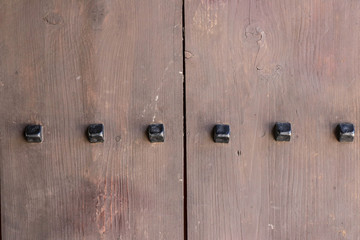 Fragment of an old wooden door of a dark brown color