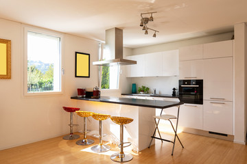 Kitchen in modern apartment with island and stools