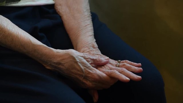 Elderly woman's clasped hands with copy space