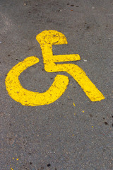 A close up view of a orange painted paraplegic sign to show a designated parking only