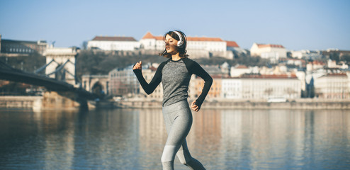Woman in sportswear running on Danube river promenade in Budapest