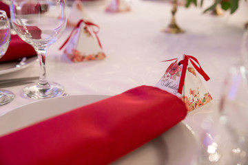 close up table decor for wedding ceremony, table setting, flowers, red and white decor