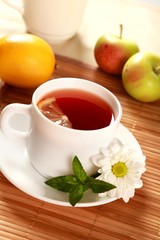 Obraz na płótnie Canvas Tea with lemon slice fruit and a flower