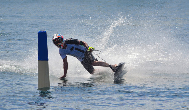 Motosurf Competitor taking corner at speed making a lot of spray.