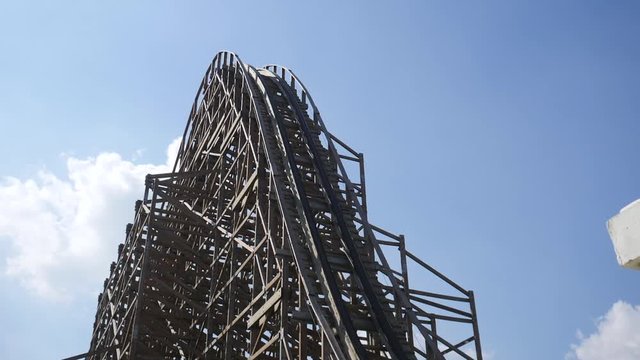 Shot of wooden roller coaster with blue sky at background