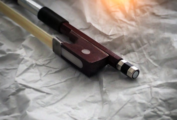 Naklejka premium In selective focus of violin bow frog and violin bow screw,the end part of a stringed musical instrument's bow,blurry light around