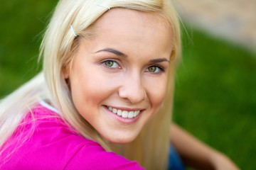 Portrait of a Smiling Young Woman in a Park