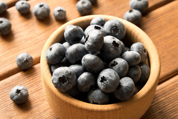 Fresh blueberries on a wooden table in a wooden plate. Close up. The concept of natural food