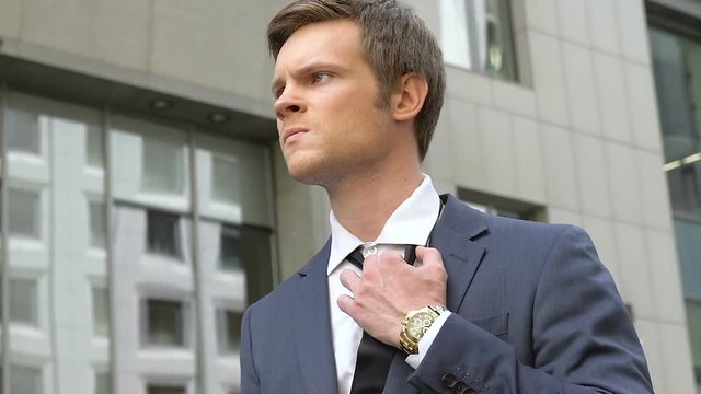 Businessman straightens tie with anger, unsuccessful meeting, unemployment