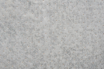 An old gray metal texture with dark spots and with metal rivets in Spain