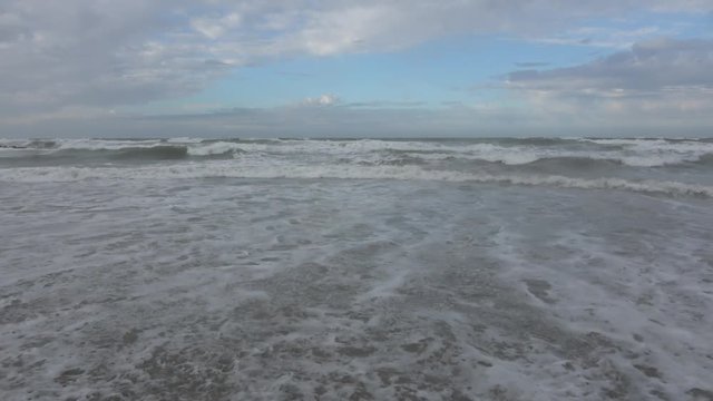 Waves rolling on the beach is a stormy day, winter mediterranean sea. Focene, Lazio, Italy. 4k