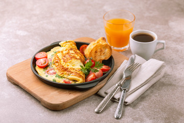 Herb omelette with tomatoes and panini toasts. Coffee. Breakfast