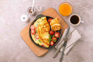 Herb omelette with tomatoes and panini toasts. Coffee. Breakfast