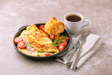 Herb omelette with tomatoes and panini toasts. Coffee. Breakfast