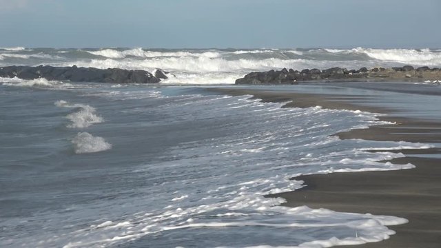 Waves rolling on the beach is a stormy day, winter mediterranean sea. Focene, Lazio, Italy. 4k
