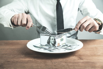 Caucasian businessman having dinner dollars. Business concept