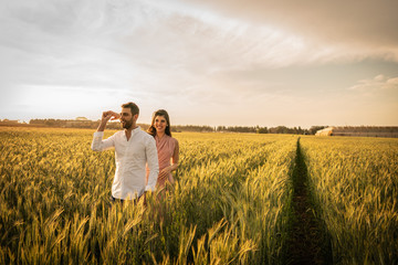 Romantic Couple on a Love Moment at gold wheat field 