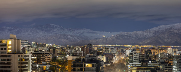 Amazing views of Santiago de Chile skyline by night with the Andes mountain range full of snow and the ski resorts working at full capacity making a wonderful horizon on a high resolution panorama