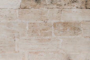 Beige grungy ancient brick stone wall in Spain