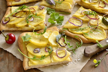 Vegetarian pizza with potatoes, red onion and greens